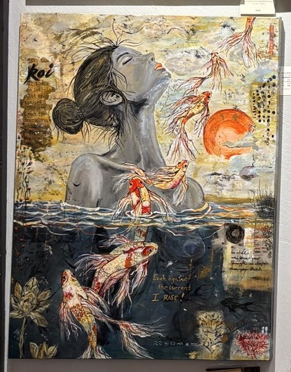 Against the Current by Rita Irvin hanging in a gallery: a woman half-submerged among koi, lotus and an orange sun